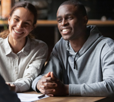 Couple smiles while meeting with insurance agent