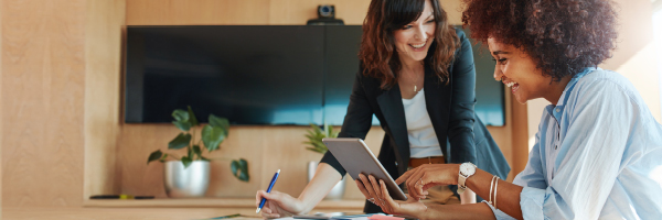 Co-workers laugh while collaborating in an office meeting room