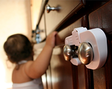 Child grabbing onto child-proofed cabinet