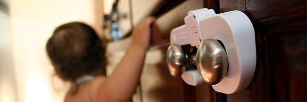 Child grabbing onto child-proofed cabinet