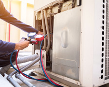 A man uses equipment to check meter levels on a home HVAC system.