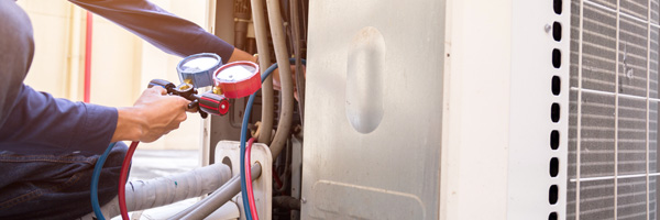 A man uses equipment to check meter levels on a home HVAC system.