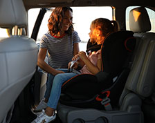 Parent grabbing child out of car seat in car 