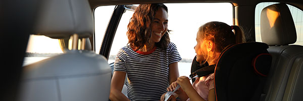 Parent grabbing child out of car seat in car 