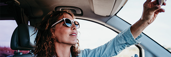 Woman adjusting rearview mirror