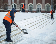 Worker outside in winter shoveling