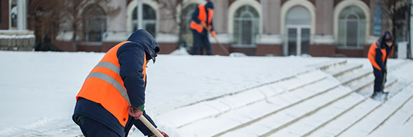 Worker outside in winter shoveling
