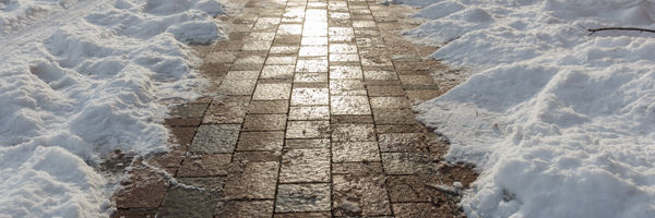 Shoveled snow clears a brick walking path.