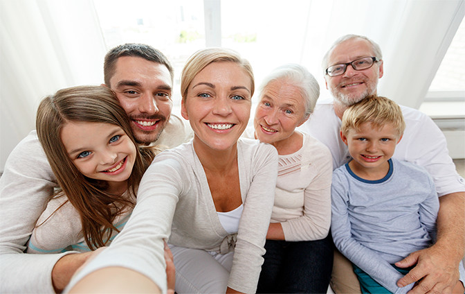 A family of people smiling while taking a picture of themselves.