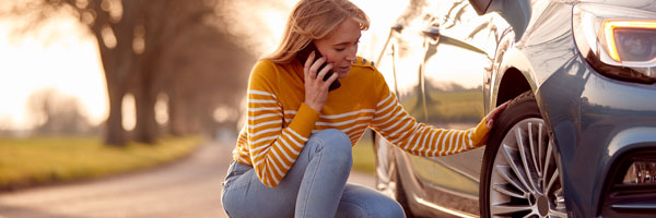 woman looking at flat tire