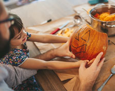 father and daughter carving pumpkins