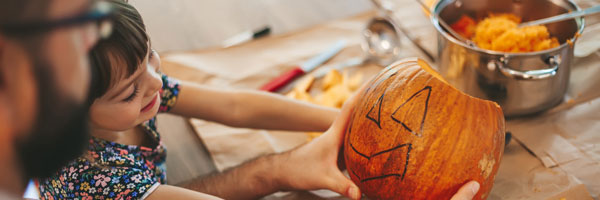 father and daughter carving pumpkins