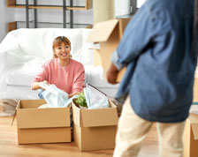 woman and man unpacking boxes in new home
