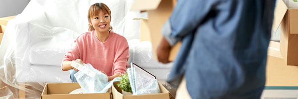 woman and man unpacking boxes in new home