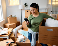 woman on phone surrounded by moving boxes