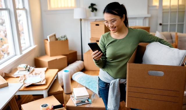 woman on phone surrounded by moving boxes