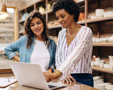 two women working on laptop in art studio