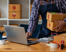 man carrying unopened boxes on laptop
